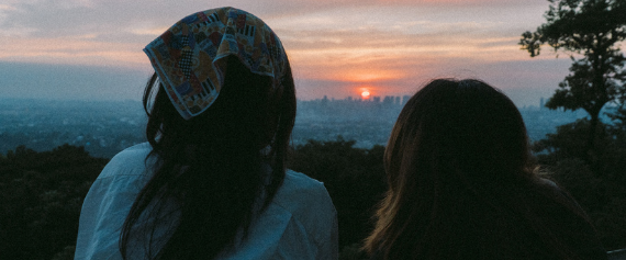 Two people looking out over the sunset together